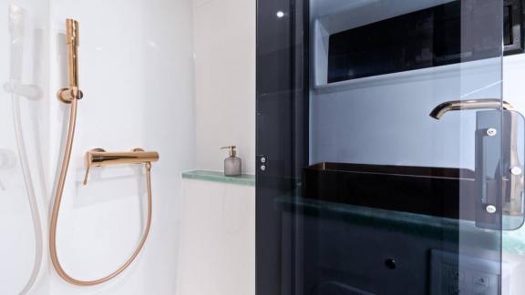 Luna 49 Red’in banyosu cam kapılı duş, altın tonlarında armatürler ve şık lavabo detayıyla tasarlandı.