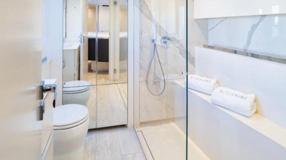 The bathroom of Sunreef 50 Solitaire features a glass shower, marble accents, and a bright, modern layout.