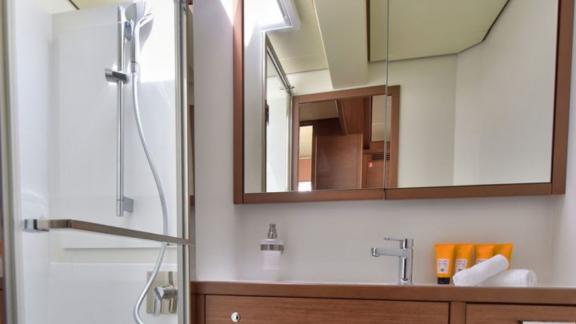 Stylish en-suite bathroom with shower and large mirror on Lagoon 450F Adriatic Tiger, perfect for onboard comfort.