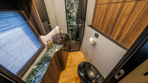 With wood paneling and dark marble, this stylish bathroom enhances the luxury charter experience in Split.