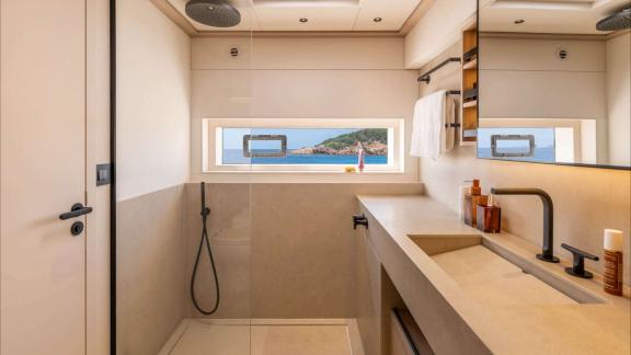 Imladris offers a spacious shower area with modern fixtures and stunning views from a wide window.