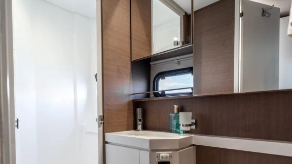 Stylish bathroom with a sink, mirrors, and natural light on the Bali Catamaran Signature Concept.