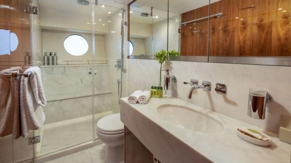 The Sunseeker 75 features a stylish bathroom with glass shower, round window and marble sink details.