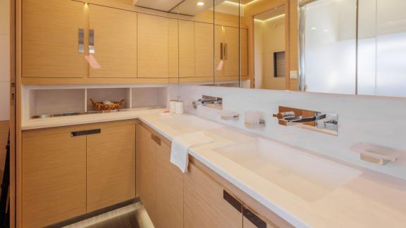 The Ariva features a modern bathroom in Corfu with twin basins, light wood cabinets and mirrored walls.