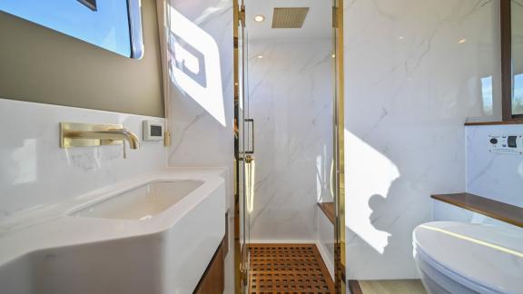 Evita power catamaran features a marble shower area, glass enclosure and a spacious sink unit.
