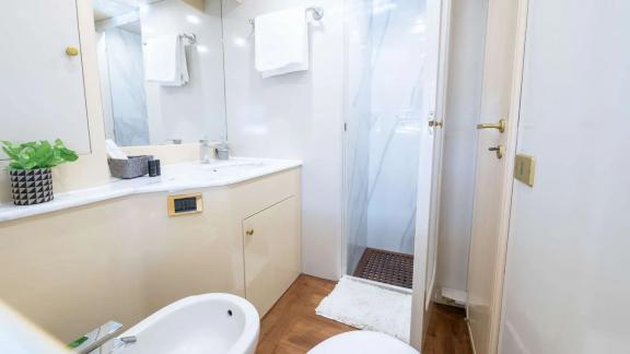 The bathroom of Wish Alfamarine 91 features a shower cabin, sink cabinet and wooden floor details.