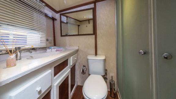 Badezimmer auf einer Gulet mit Waschbecken, Toilette und Spiegel.