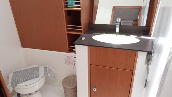 Yelkenli yat Ariti'nin lavabo, tuvalet ve depolama alanı ile donatılmış modern banyosu.