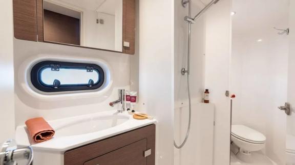 Stylish bathroom with shower and window on the Bali 4.2 catamaran, offering comfort and elegance.