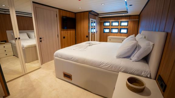 The luxurious bedroom of Almila motor yacht in Marmaris features a spacious bed and modern decor.