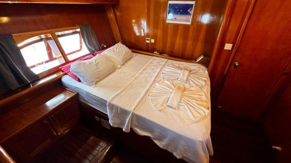 The double cabin of gulet Sea Angel 2 is furnished with wooden details and a spacious bed.