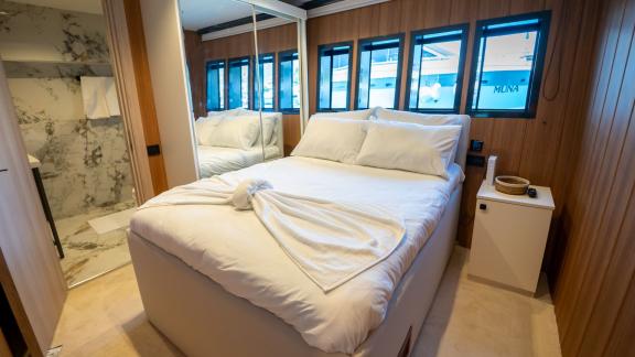 The luxurious bedroom of Almila motor yacht in Marmaris features a spacious bed and modern decor.