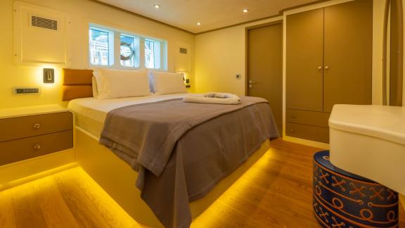 The spacious bedroom of the luxury trawler Lycian Dream in Fethiye features a comfortable bed and modern decor.