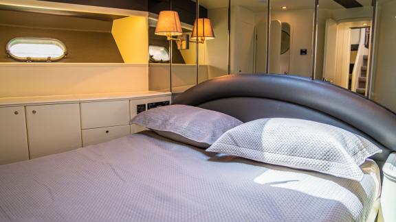 The bedroom on Alfa F yacht features a large bed and modern lighting.