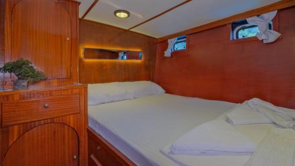 Gästekabine auf dem Trawler Grainne Mhaol mit Doppelbett und Holzelementen.