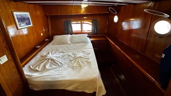 The spacious double cabin of gulet Sea Angel 2 is furnished with a comfortable bed and wooden decor.