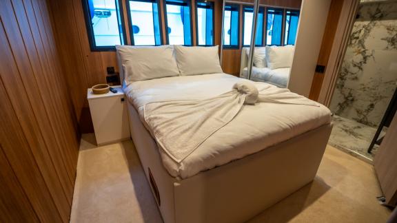 The comfortable bedroom of Almila motor yacht in Marmaris features a cozy bed and elegant decor.