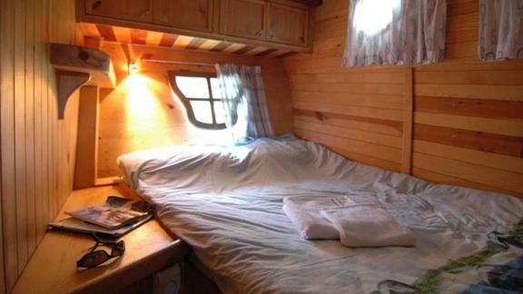 Double bed cabin with wood paneling and reading light on Gulet Ali Aga 1 in Göcek.