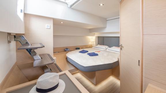 Modern and cozy bedroom on the Serenissima catamaran with natural light.