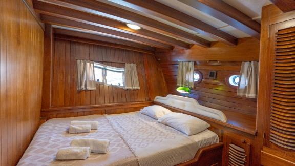 Hochwertige Kabine auf der Yacht Serenad mit Doppelbett, eleganter Holzausstattung und gemütlicher Atmosphäre.