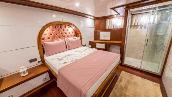 The cabin features a stylish bed, elegant decor, and a private bathroom for ultimate comfort.