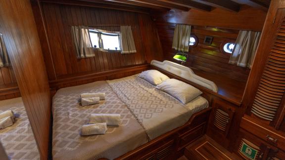 Komfortable Kabine auf der Yacht Serenad mit großem Doppelbett, eleganter Holzausstattung und gemütlichem Ambiente.