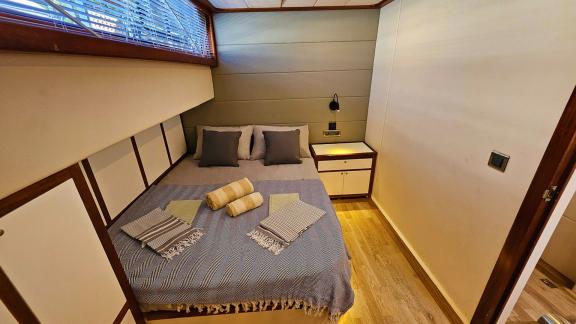 Stylish guest cabin on Gulet Arni with a comfortable bed and chic design.