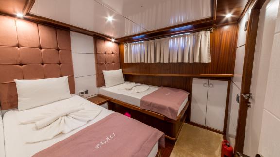 The twin cabin features two comfortable beds, stylish interior, and practical storage space.