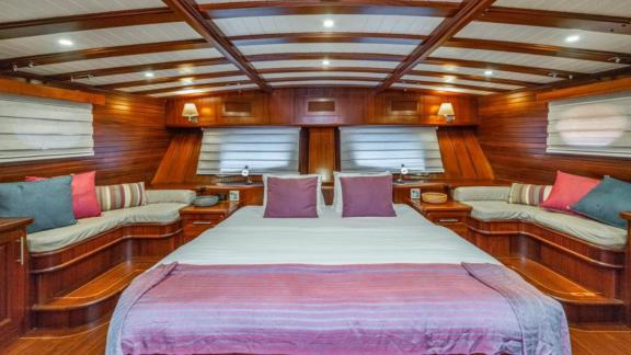 Elegant master cabin with a large bed and cozy seating area on the Gulet Semra Tuana.