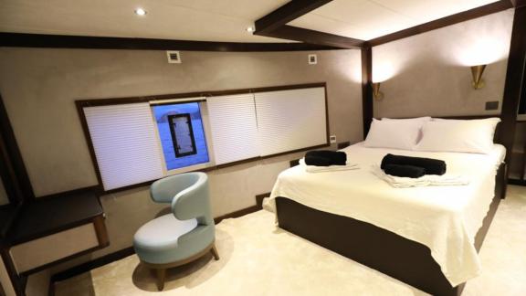 Luxurious double bedroom on the trawler Nayk 3, featuring a comfortable seating area.