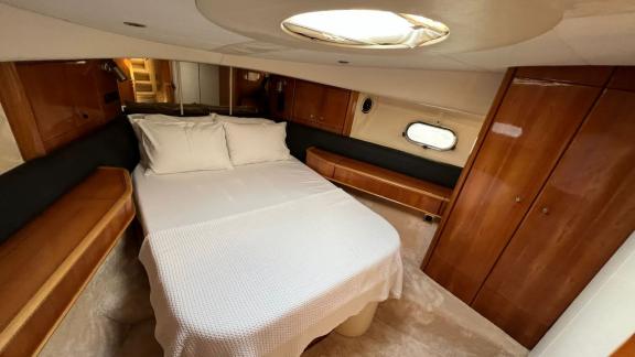 The bedroom on motor yacht Sky 22 offers a large bed and a cozy atmosphere.