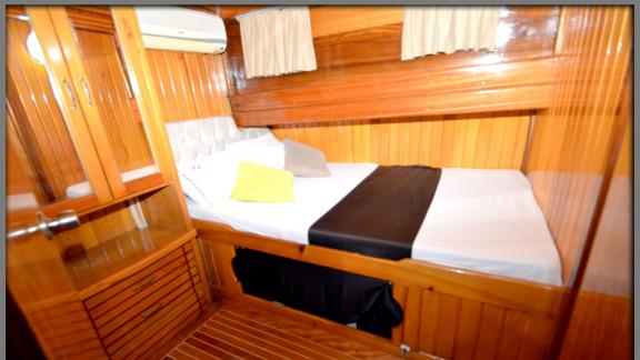 Komfortable und stilvolle Kabine mit Doppelbett und Holzverkleidung an Bord einer Gulet.