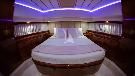 The master cabin of the Hasard yacht features a spacious bed and modern lighting.