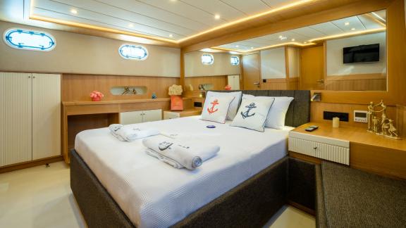 Komfortable Kabine auf der Yacht Ok Ay mit Doppelbett, stilvollem Dekor und Tageslichtfenstern in Fethiye.