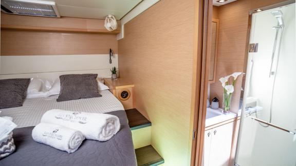 The bedroom on Catamaran Lucky Clover offers comfort with direct access to a modern bathroom.