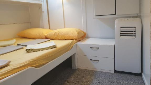 Bright cabin with double bed, yellow linens, and air conditioning on Gulet Arancia.