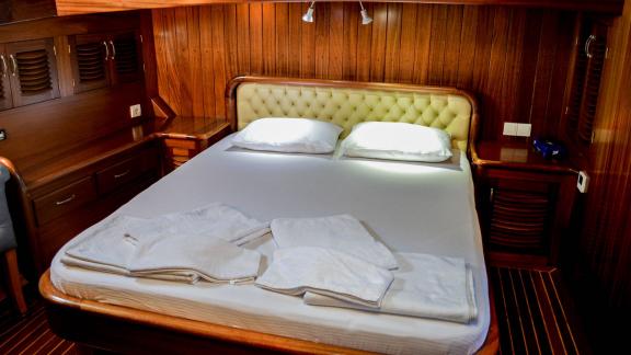 The Enderim A cabin offers a cosy double bed with wooden panelling.