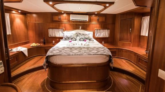 The spacious master cabin on Gulet Seven 1 features wooden details and a comfortable double bed.