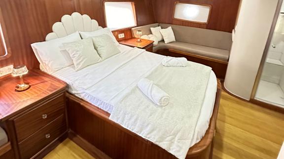 Gemütliches Schlafzimmer auf der Gulet-Yacht mit Doppelbett, Sitzbank und eigener Dusche.