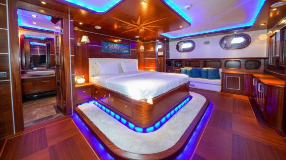 A spacious, luxurious cabin on the gulet with stylish lighting and fine wood panelling.