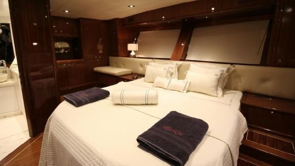 Spacious cabin of the Gulet Didi with large bed, elegant wood panelling and stylish lighting.