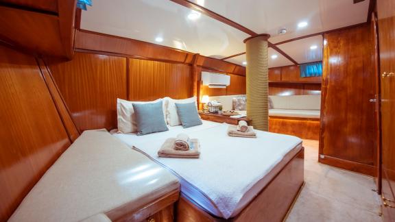 Elegant bedroom on the Gulet Rüya with a cozy double bed and stylish wooden interior.