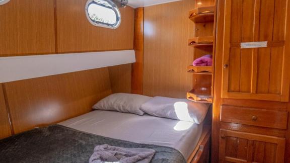 Compact and cozy cabin on Gulet Avuncan with a double bed and practical storage space.