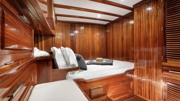 Wood-paneled cabin with a comfortable bed on Serenad A.