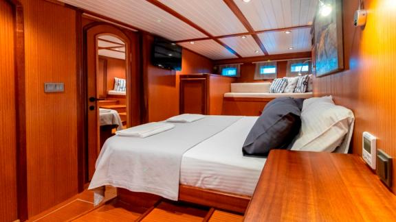 Master cabin of the luxurious Gulet Bodrum Queen in Bodrum, Turkey, with a double bed and cozy furnishings.