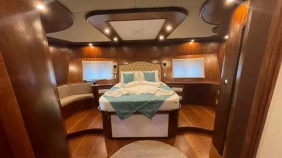 Luxurious master cabin with elegant woodwork and stylish bed.