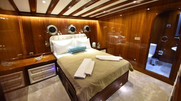 Elegant double cabin on the Gulet Kayhan 11 in Fethiye with a comfortable bed and fine wood decor.