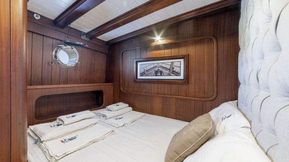 Gemütliche Kabine mit Doppelbett und Rundfenster auf der Gulet-Yacht Jasemin 1.