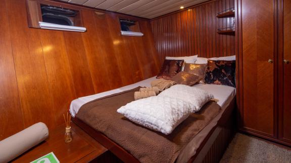 Comfortable double cabin with fine wood furnishings and soft cushions, ideal for relaxing.