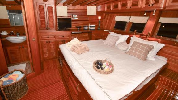 The double cabin of gulet Barka offers comfortable accommodation with a large bed and wooden details.